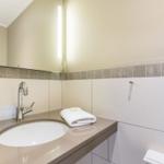 Bad mit Waschbecken, Spiegel und Handtuch