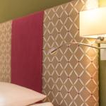 Bettkopfteil mit gemustertem Stoff und Wandlampe