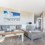 Wohnzimmer mit Sofa, Kamin und Wandbild