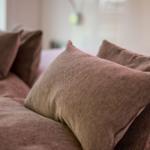 Headboard with pillows and bedding in brown tones