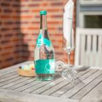 A water bottle and a glass with a napkin are on the table.