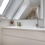 Badezimmer mit Waschbecken, Spiegel und Dachfenster