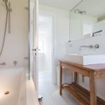 Bad mit Badewanne, Dusche und Waschtisch auf Holzkonsole