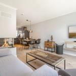 Wohnbereich mit Kamin, Esstisch und Fernseher an der Wand.