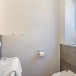 Badezimmer mit Waschbecken, Toilette und Fenster