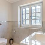 Badezimmer mit Toilette, Waschbecken und Fenster.
