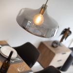 Esstisch mit Weinflasche und Lampe