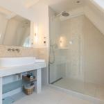 Badezimmer mit Dusche und Waschbecken unter Dachschräge