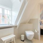 Sanitärzimmer mit Toilette und Fenster. Durchgang zur Schlafzimmer.