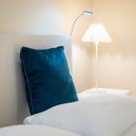 Bettkopf mit Kissen und Nachttisch mit Lampe