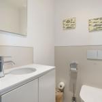 Badezimmer mit Waschbecken, Spiegel und Toilette. Wandbilder zeigen Fische.