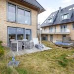 Terrasse mit Sitzgruppe und Hängematte im Garten. Modernes Haus mit Holzfassade.