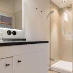 Bad mit Dusche und Waschbecken mit Spiegel