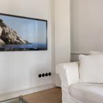 Wohnzimmer mit Sofa und Wandbildschirm