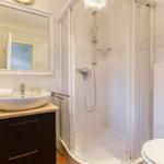 Badezimmer mit Dusche, Waschbecken und Toilette.