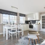 Kitchen with dining table, TV, and bedroom in background