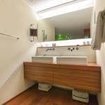Badezimmer mit zwei Waschbecken, Spiegel und Handtuchhalter.