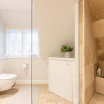 Badezimmer mit Toilette, Dusche und Fenster mit Jalousie