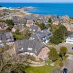 Häuser mit Dächern und Grünflächen am Meer