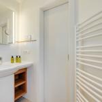 Bathroom with sink, mirror, and radiator