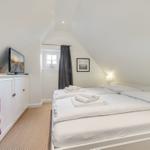 Bedroom with double bed, TV, and window