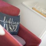 Red armchair with cushion and desk in background.