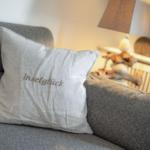 A gray sofa with a pillow that reads Inselglück.