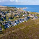 Aerielansicht einer Küstenstadt mit Häusern und blauem Meer