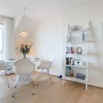 Essbereich mit Tisch, Stühlen und Bücherregal an der Wand.