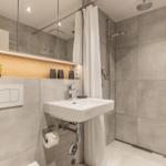 Bad mit Dusche, Waschbecken und Spiegelschrank. Holzregal mit Pflegeprodukten.