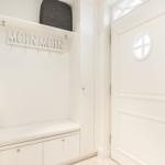 Eingangsbereich mit weißem Schuhschrank und runder Tür