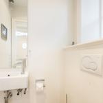 Badezimmer mit Waschbecken, Spiegel und Fenster mit Segelbootmodell.