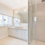 Badezimmer mit Dusche, Waschbecken und Fenster