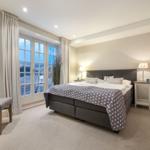 Schlafzimmer mit Doppelbett, Fenster und Sessel
