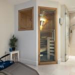 Sauna mit Glaswand, Dusche und Liege im Bad