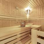 Holzsauna mit Bank, Eimer und Thermometer an der Wand.