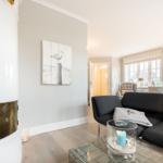 Wohnzimmer mit Sofa, Kamin und Wandbild