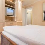 Schlafzimmer mit Bett, Kleiderschrank und Fernseher.