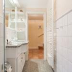 Badezimmer mit Waschbecken, Spiegel und Heizkörper