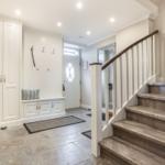 Eingangsbereich mit Garderobe, Sitzbank und Treppe.