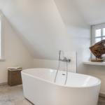Duschbad mit Fenstern und Holzskulptur