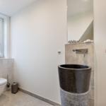 Badezimmer mit Toilette, Waschbecken und Fenster.