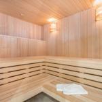 Sauna mit Holzbank, Holzwand und weißen Handtüchern.