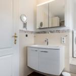 Badezimmer mit Waschmaschine und Spiegelschrank