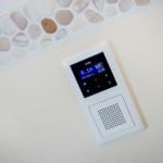 Wandmontierte Audio-Einheit mit Steuertasten und Display.