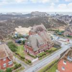 Village with thatched houses and view of the North Sea