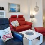 Red sofa, blue armchair, and white coffee table in the living room