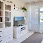 Living room with TV, bookcase, and view of balcony