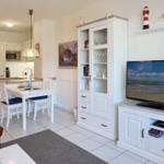 Living and dining area with TV, cabinet, and kitchenette.