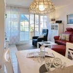 Living and dining area with red sofa, dining table, and glass ceiling.